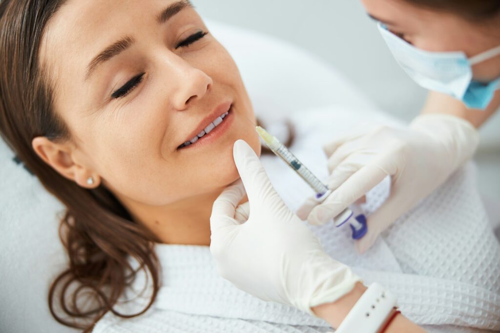 Pleased dark-haired woman getting an anti-wrinkle injection