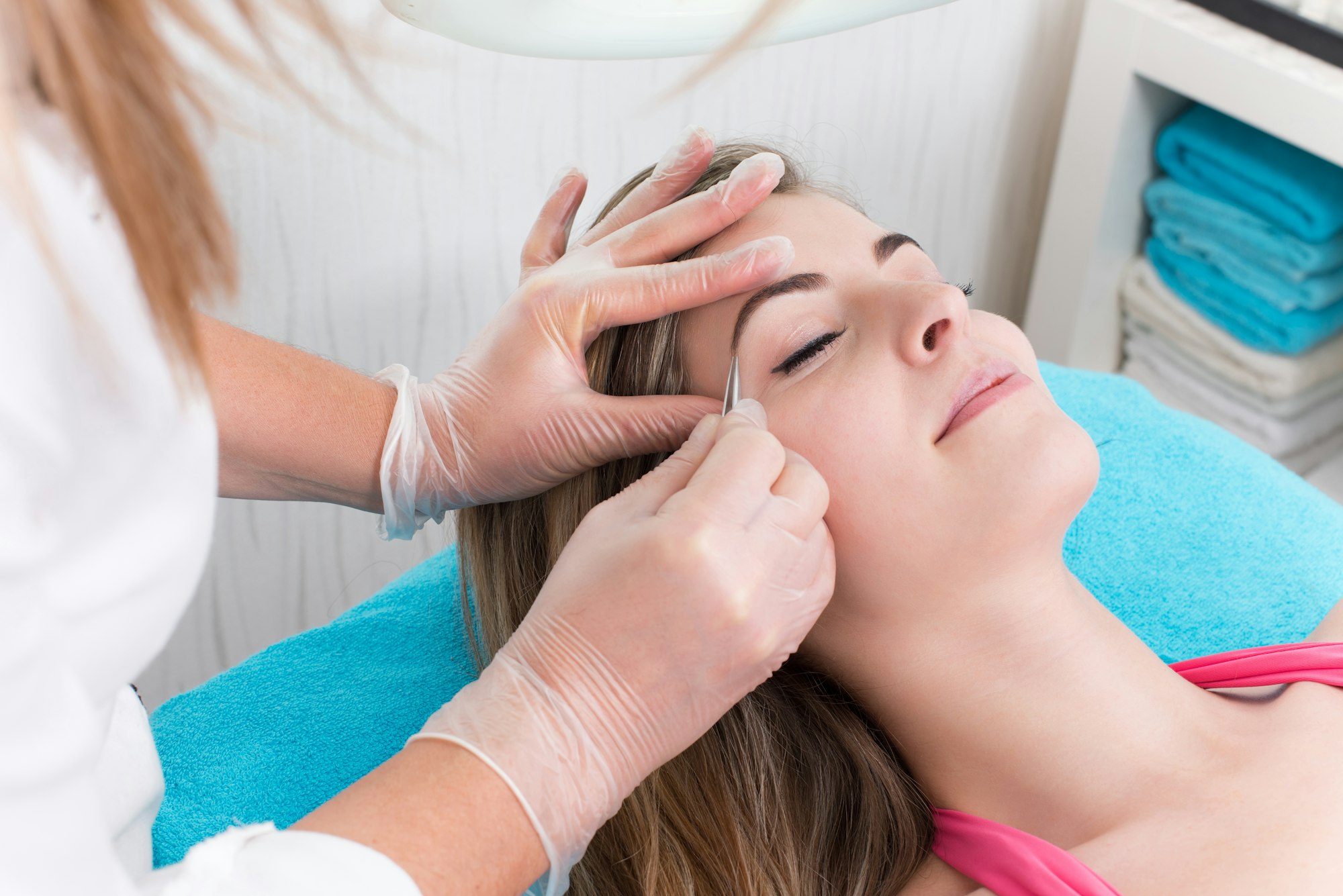 Woman getting tweezing eyebrow